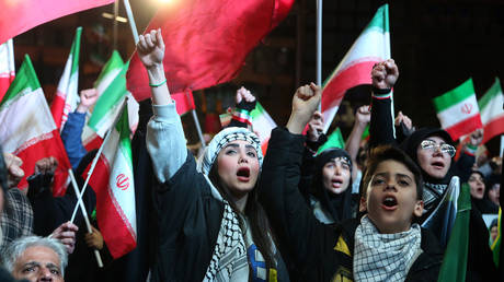 Iranians gather in Enqelab Square to protest Israeli and US attacks on their country, carrying Iranian flags and photos of Iranian supreme leader Ali Khamenei, who was killed in an airstrike, March 30, 2026.
