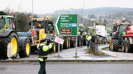 A police officer directs traffic as slow-moving vehicles join a fuel protest causing severe traffic disruption on the A5 between Belfast and Omagh, April 14, 2026.