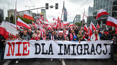 FILE PHOTO. People hold banners and the Polish national flag during an anti immigration protest on May 10, 2025 in Warsaw, Poland.