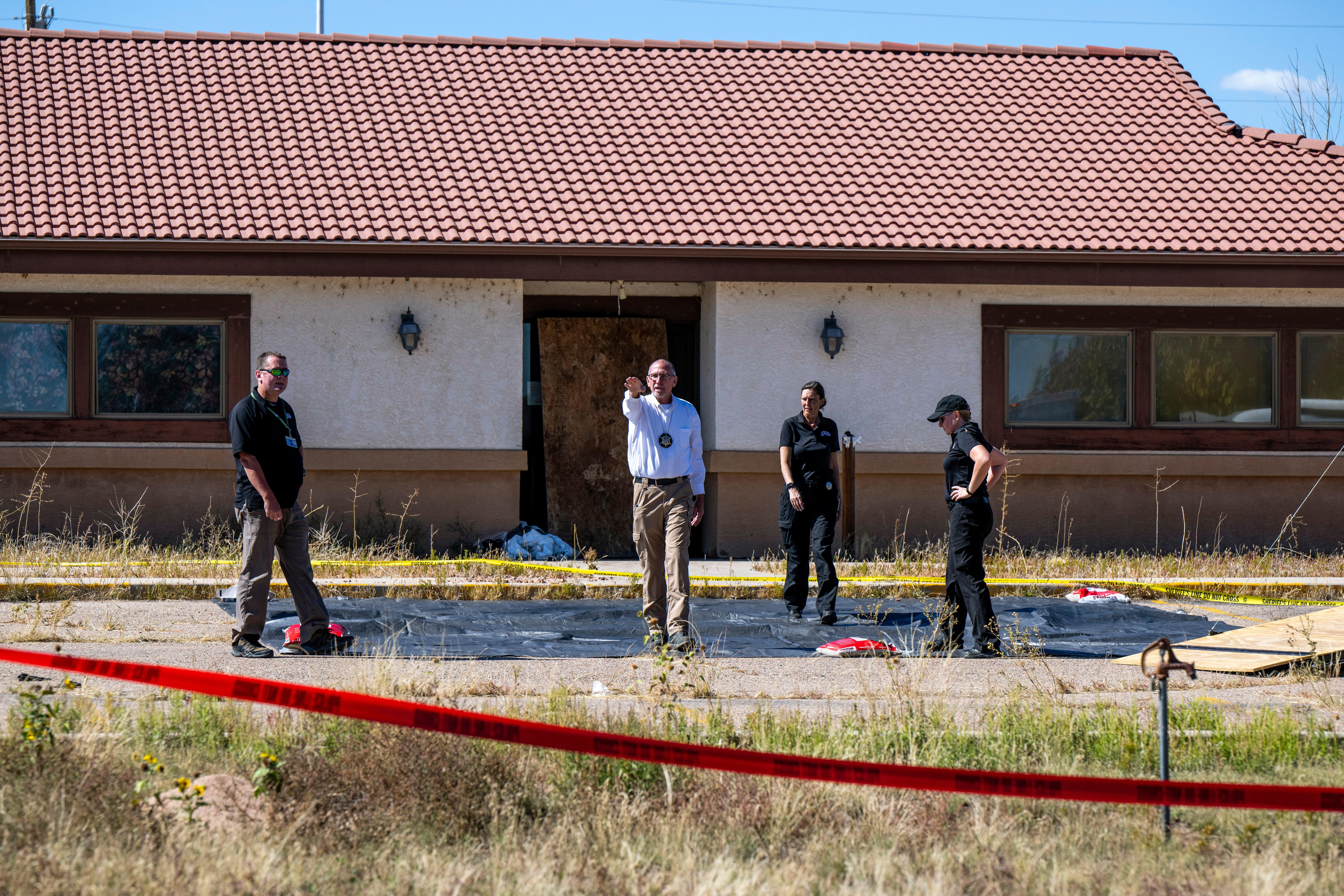 FILE – Fremont County coroner Randy Keller, center, and other...