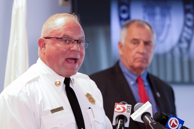 State Fire Marshall Jon Davine speaks during a press conference at the office of Bristol County District Attorney Thomas Quinn, at right, Tuesday, in Fall River. (Mark Stockwell/Boston Herald)