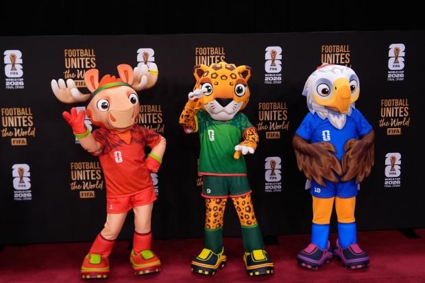 The tournament mascots pose on the red carpet as guests arrive for the draw 