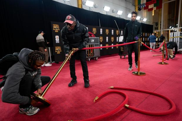 Workers prepare the red carpet area prior to the final draw 