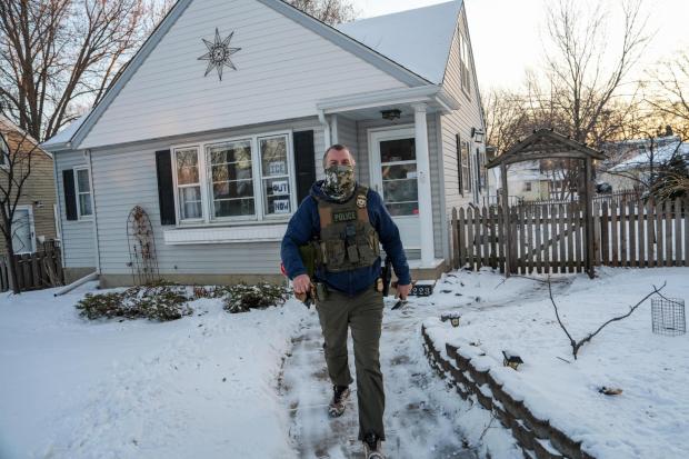 A federal agent conducts an immigration enforcement operation in a neighborhood on Monday, Feb. 2, 2026, in Minneapolis. (AP Photo/Ryan Murphy)