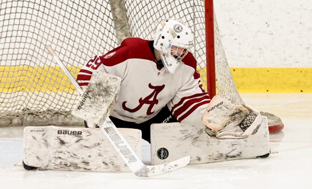 Arlington goalie John Snider makes a save during the second period of a boys ice hockey game earlier this season. (Mark Stockwell/Boston Herald)