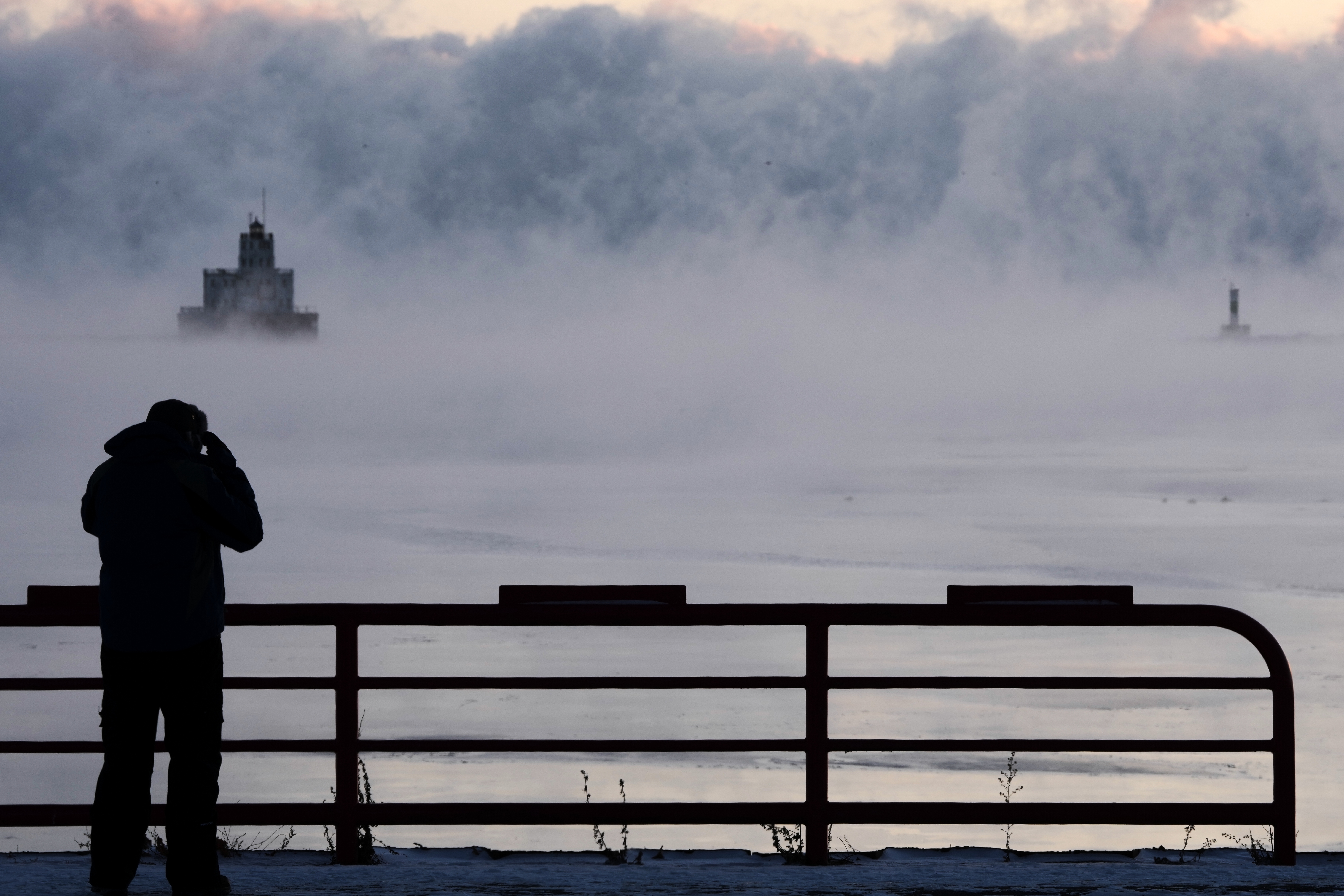 Doug Kunde watches as steam is seen over Lake Michigan...