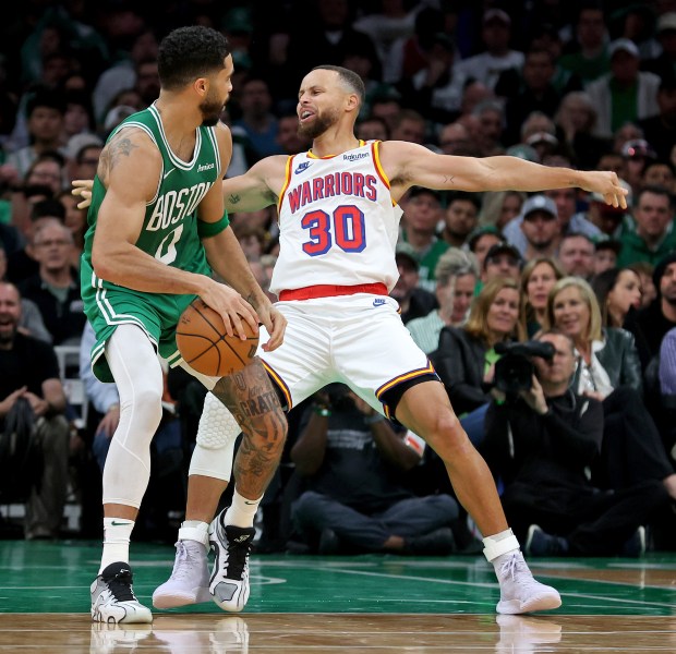 Stephen Curry (30) of the Golden State Warriors fakes a foul against Jayson Tatum of the Boston Celtics during the first half. (Photo By Matt Stone/Boston Herald)