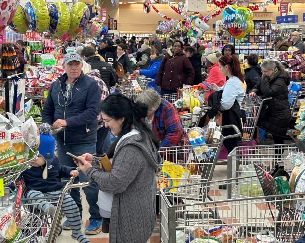 Shoppers check out in lines up to seven deep at the Market Basket in Attleboro Friday. (Mark Stockwell/Boston Herald)