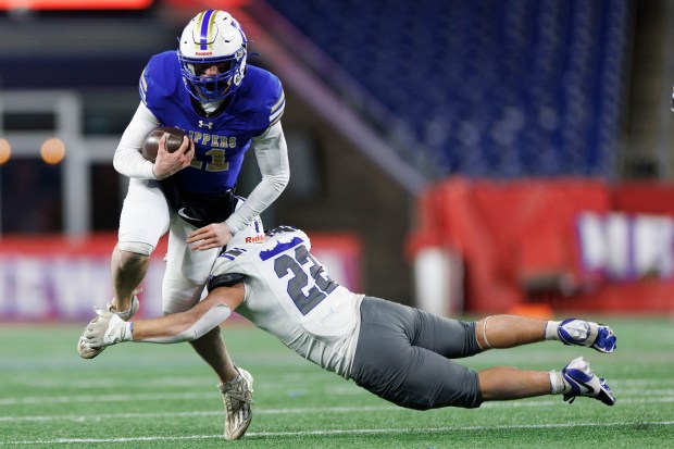 Norwell's Jack Luccarelli avoids the tackle of Fairhaven's Aaron Lague, right, during the first half Thursday night in Foxboro. (CJ Gunther/Boston Herald)