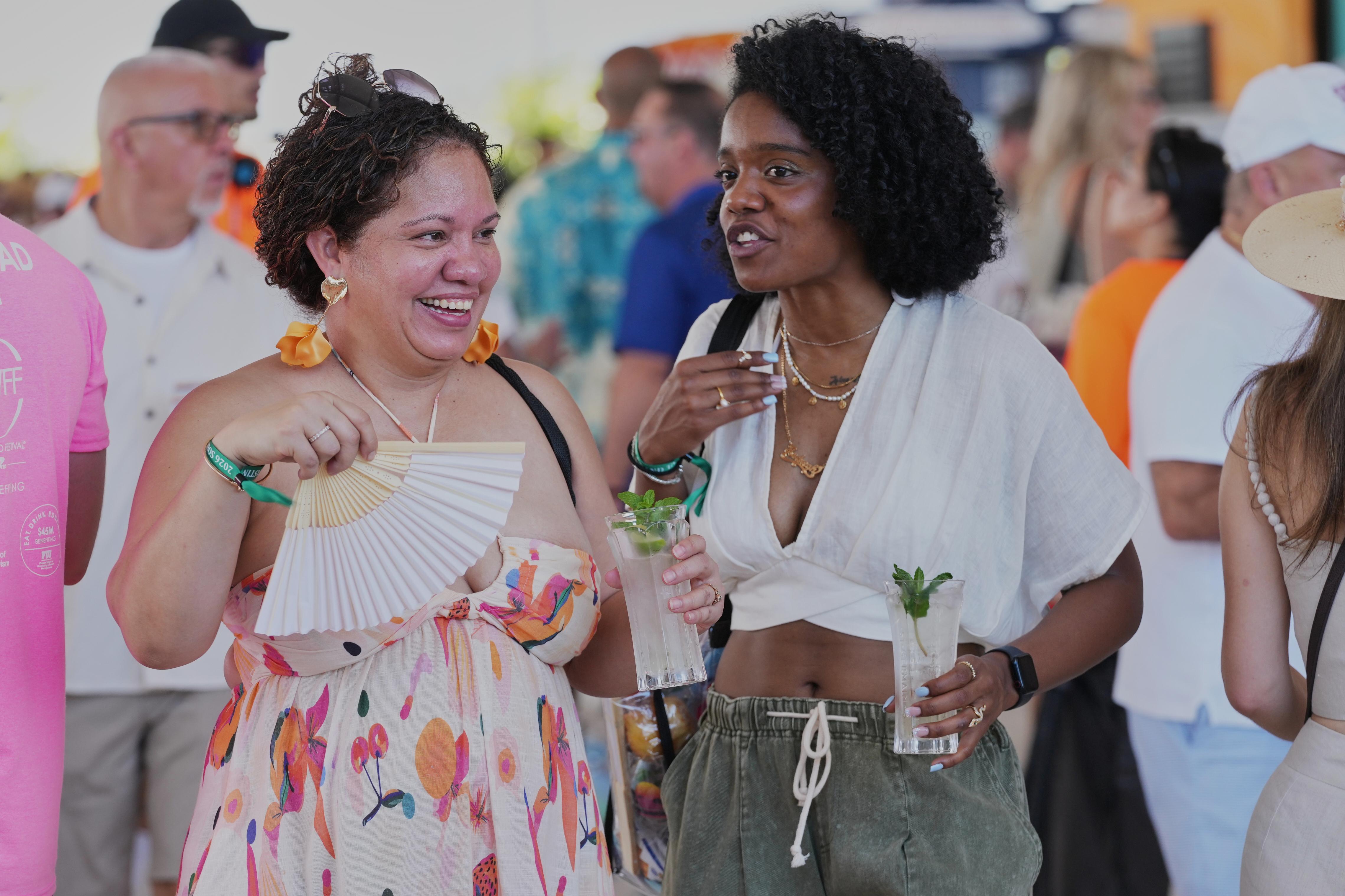 Friends walk the South Beach Wine and Food Festival Saturday,...