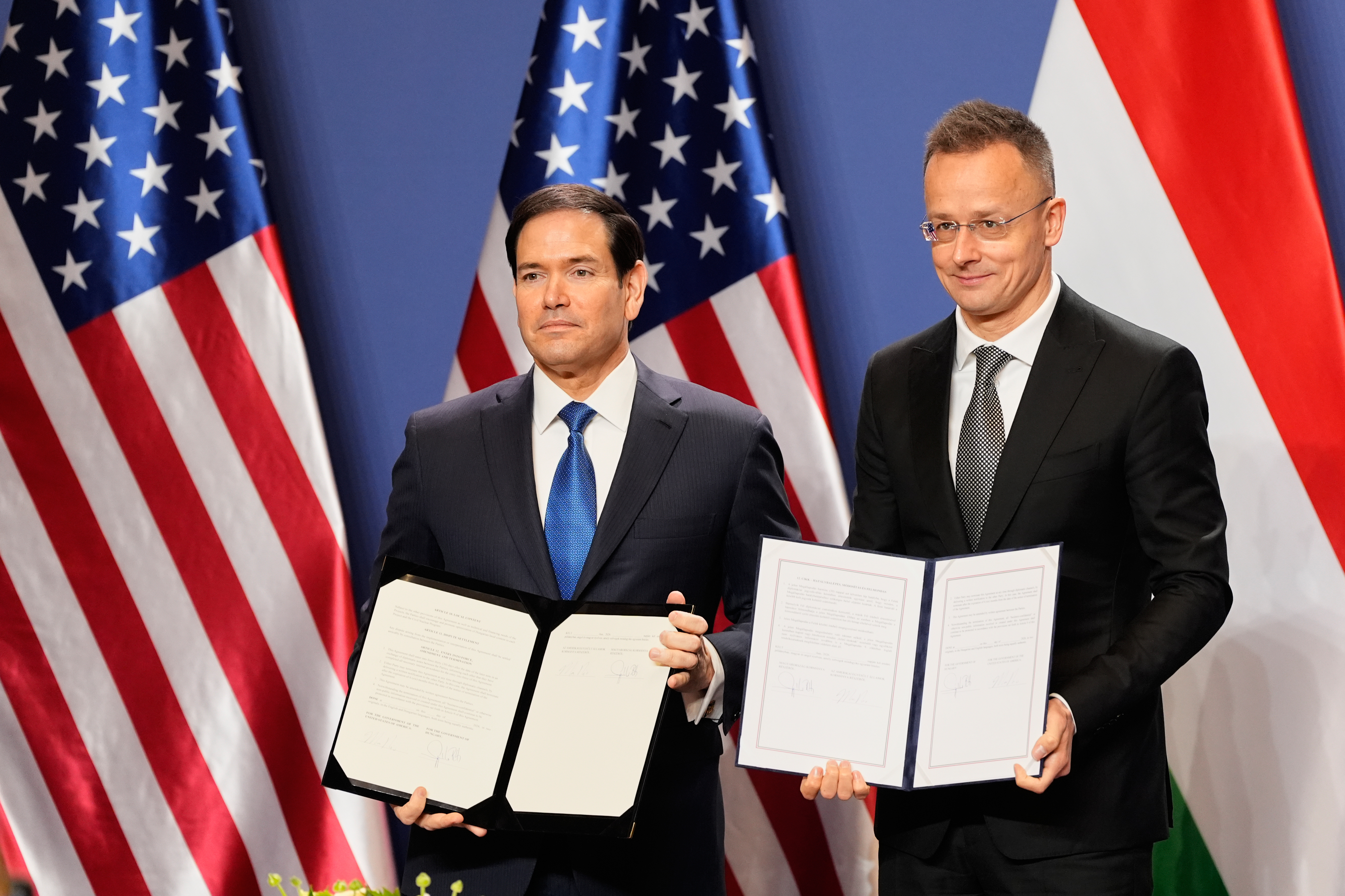 U.S. Secretary of State Marco Rubio and Hungary's Foreign Minister Peter Szijjarto pose with documents.