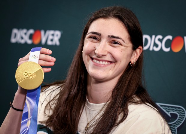 Megan Keller, who scored the winning goal in the women's Olympic hockey title game, holds her gold medal during a press conference Thursday at the Boston Sports Institute in Wellesley. (Mark Stockwell/Boston Herald)