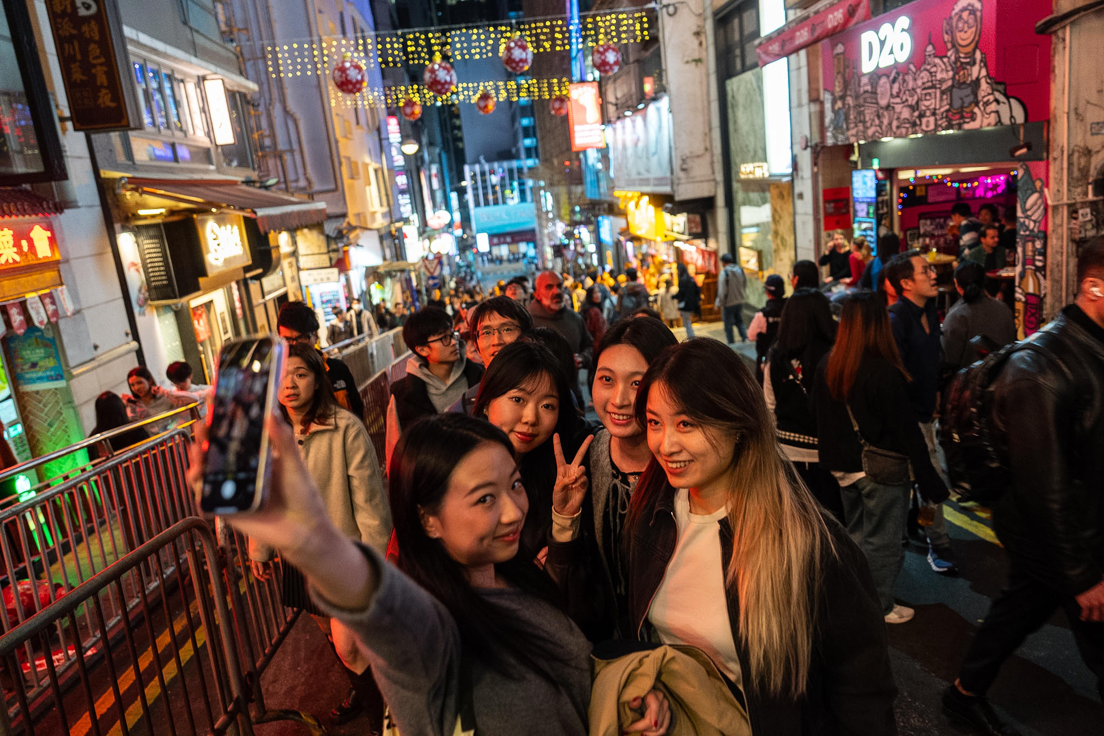 People take selfies at Lan Kwai Fong to celebrate the...