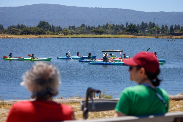 People watch kayakers at Shoreline Lake in Mountain View in June 4. (Shae Hammond/Bay Area News Group)