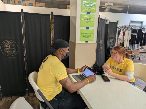 Elyse Stevens, a primary care and addiction medicine doctor, and her husband, Aquil Bey, a paramedic, discuss patient cases at a community breakfast for homeless people in New Orleans. (Aneri Pattani/KFF Health News/KFF Health News/TNS)