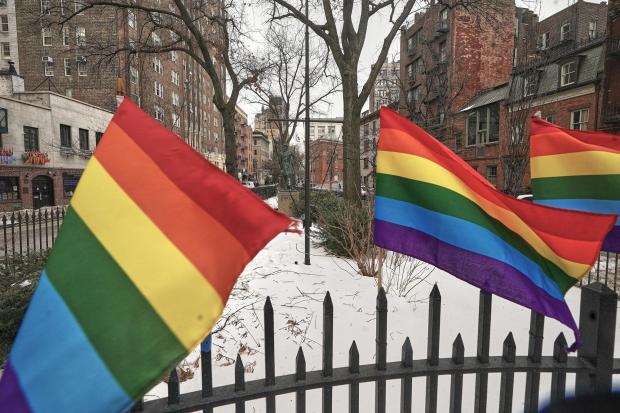 Small Pride flags adorn a fence in the Stonewall National Monument while the Trump administration has stopped flying a rainbow flag on the pole, center, in New York, Tuesday, Feb. 10, 2026. (AP Photo/Richard Drew)