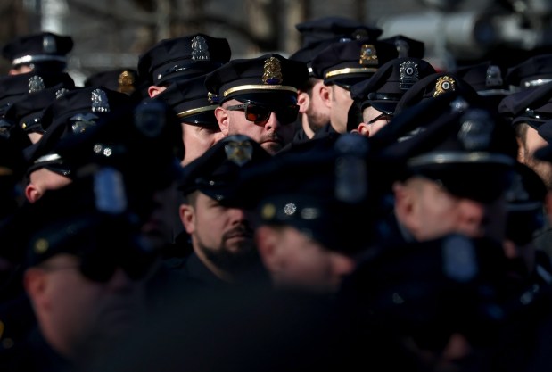 Police officers from Massachusetts and Rhode Island stand outside of St. Mary's Church, Thursday, in Franklin during the funeral service for fallen Uxbridge police officer Stephen LaPorta. LaPorta died after getting hit by a tractor-trailer on Jan. 7 while assisting a motorist. (Mark Stockwell/Boston Herald)