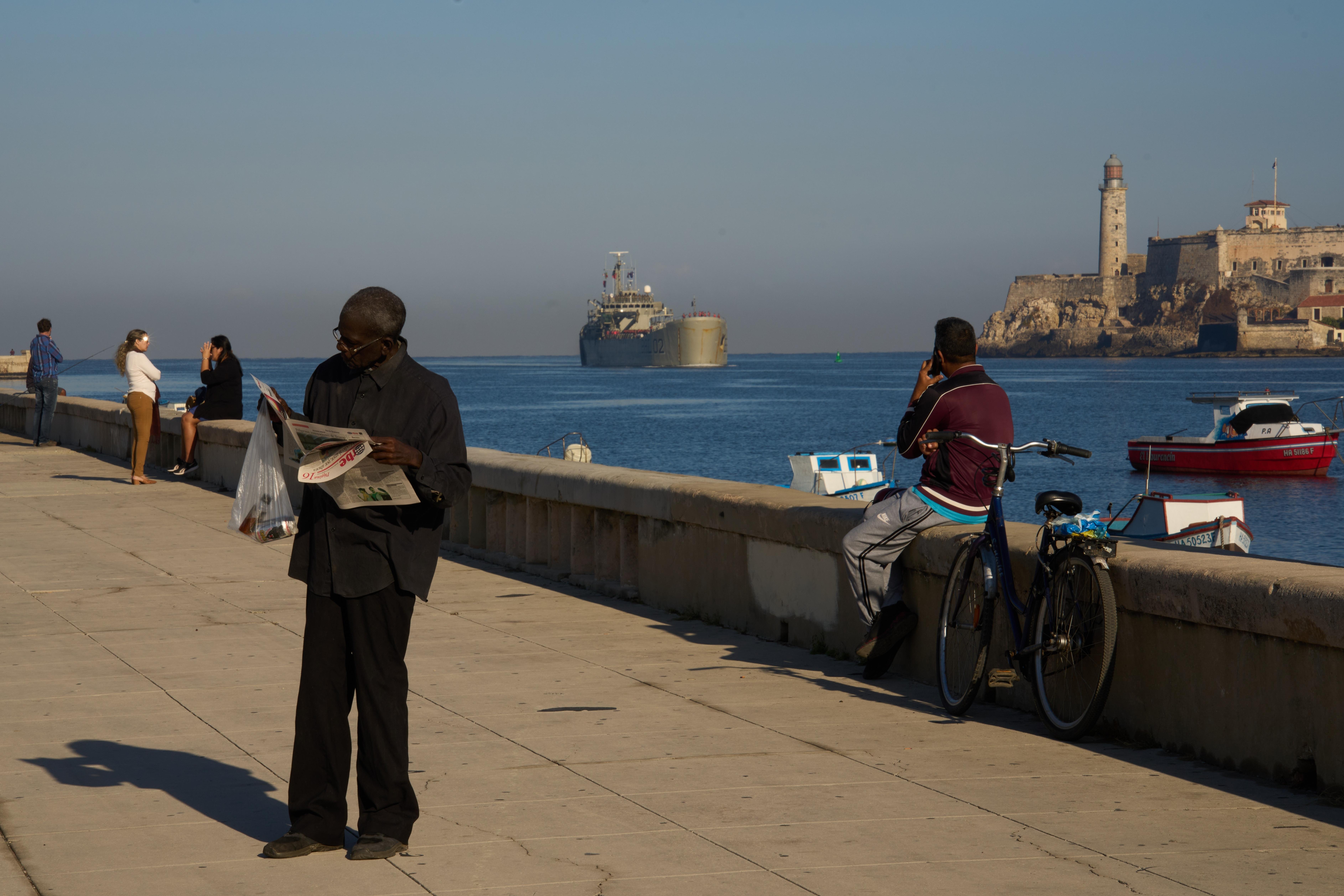 A man reads a newspaper at the Havana Bay where...