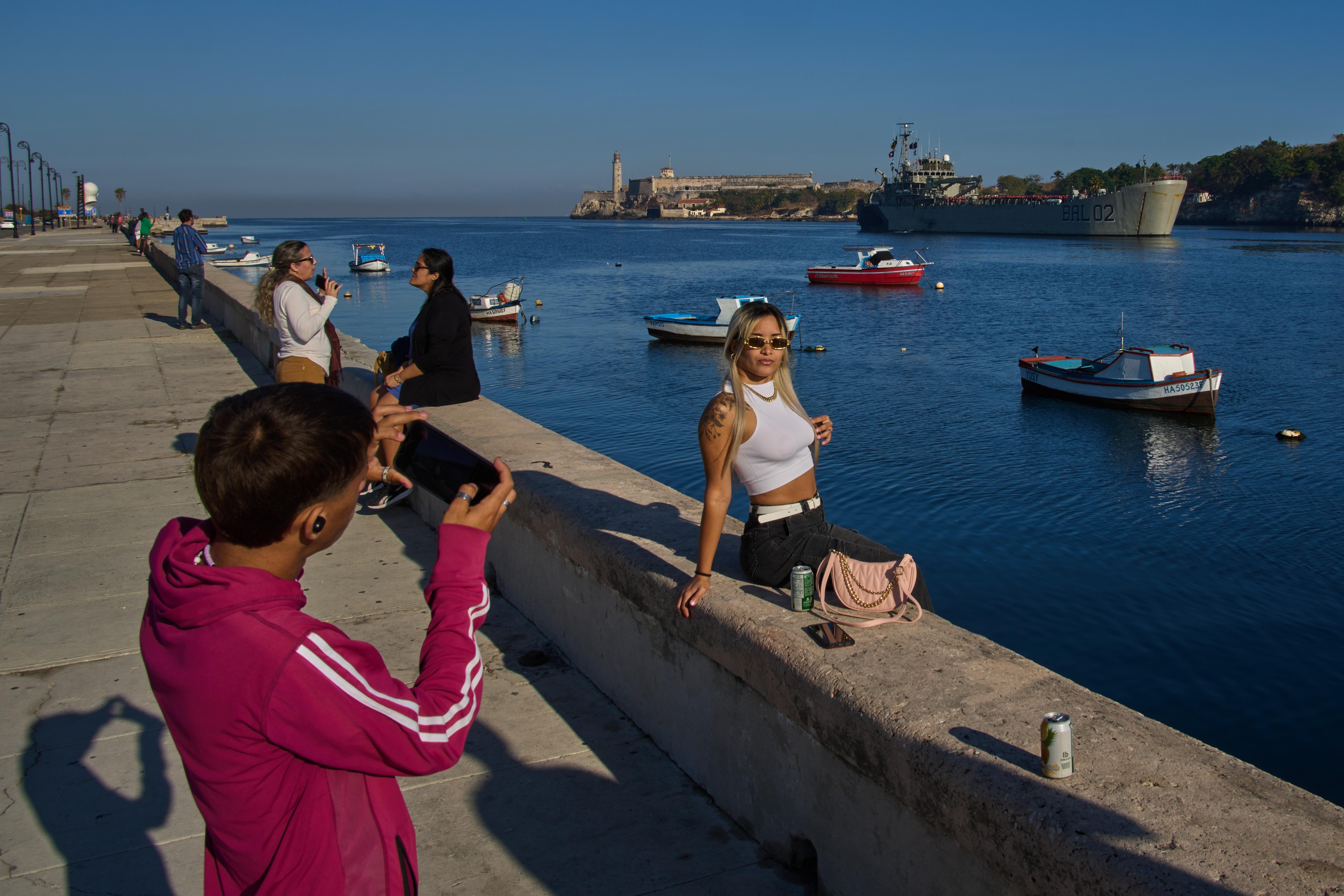 People take photos at Havana Bay as the Mexican Navy...