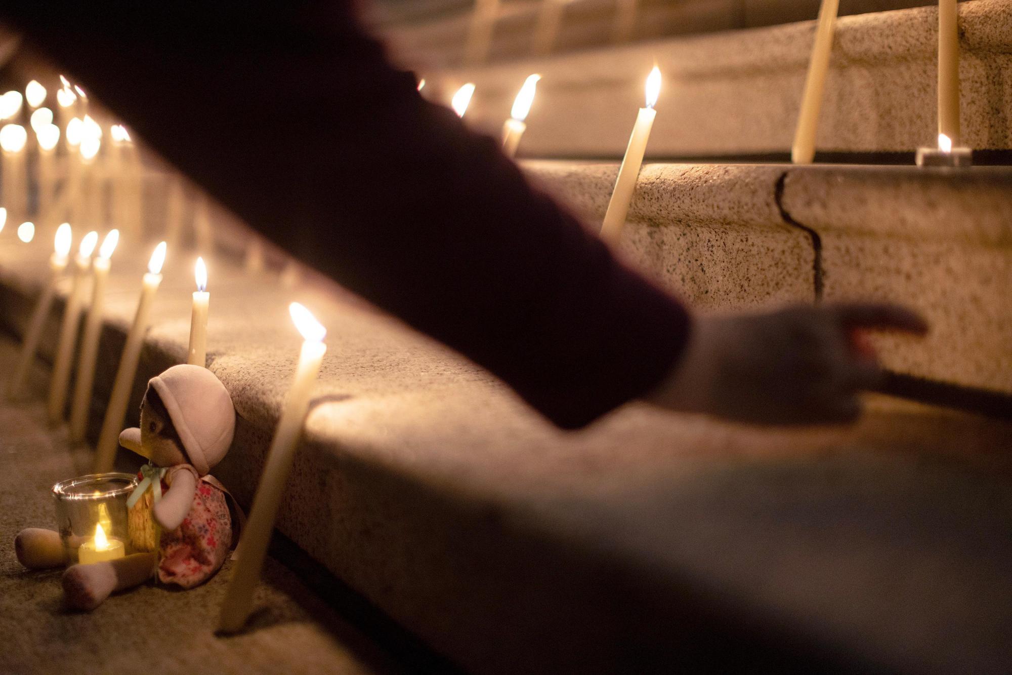 People attend a candle light vigil at the front steps...