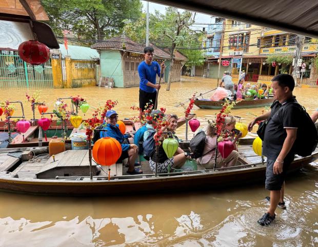 Mr. Nam, right, loads our AdventureWomen group into boats he hired to transport us across the flooded streets of Hoi An. (Lori Rackl/Lori Rackl/TNS)