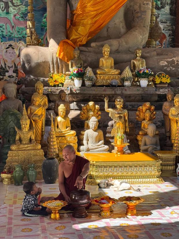 A Buddhist monk talks to a child not too far from the famed temple complex of Angkor Wat in Cambodia, where we spent the final two days of the trip. (Lori Rackl/Lori Rackl/TNS)