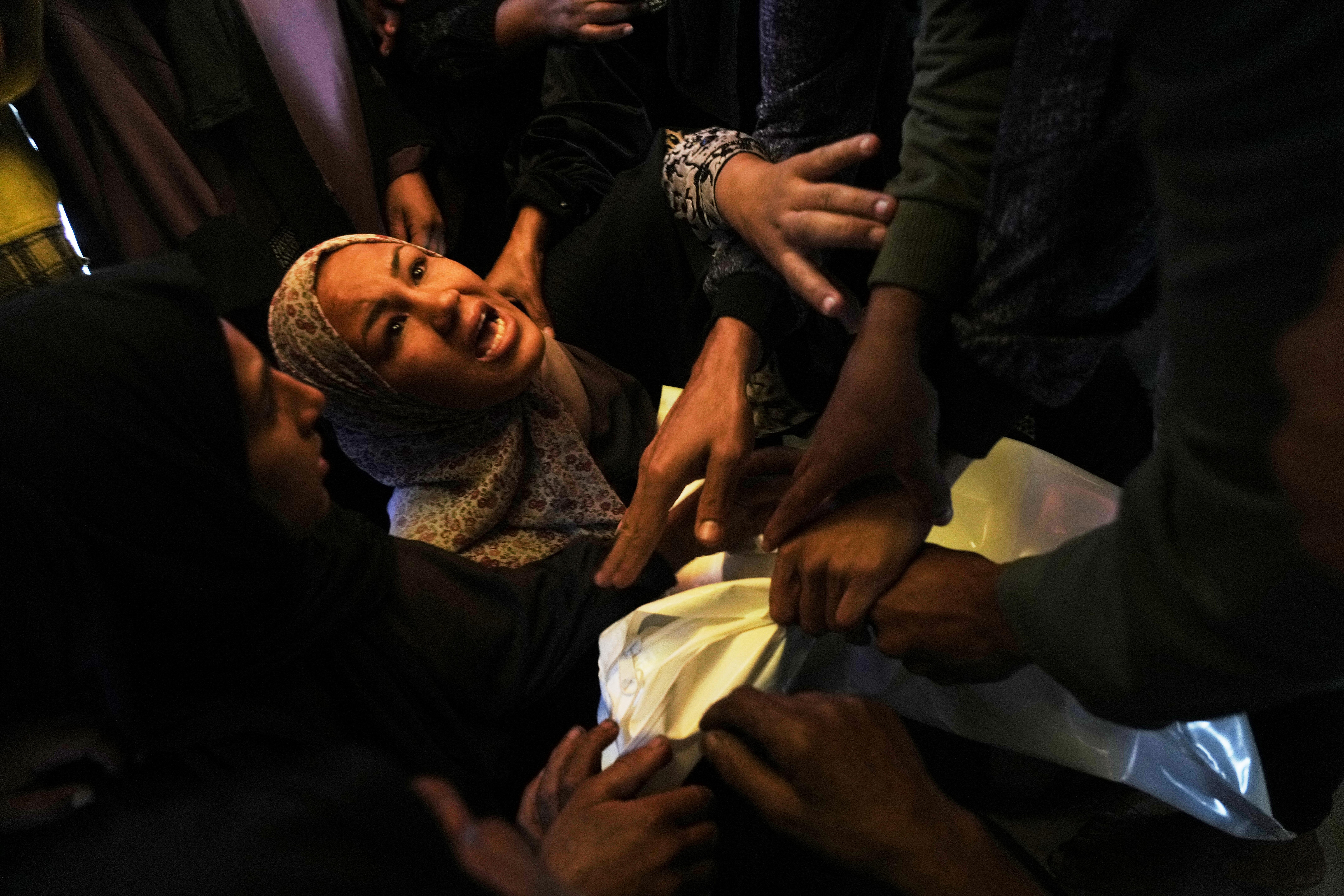 Khadija Abu Rabi mourns over the body of her son,...