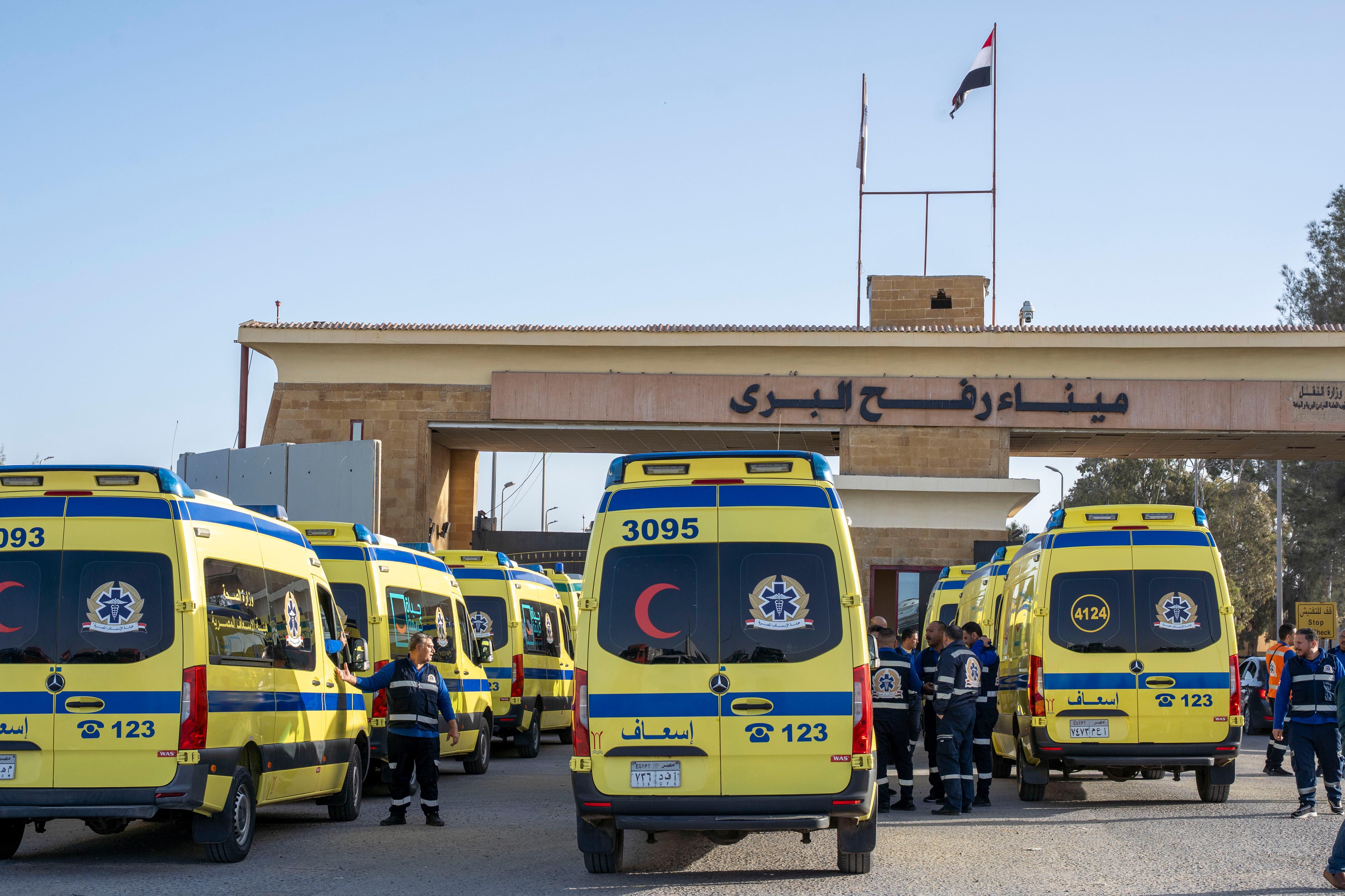 Ambulances line up to enter the Egyptian gate of the...