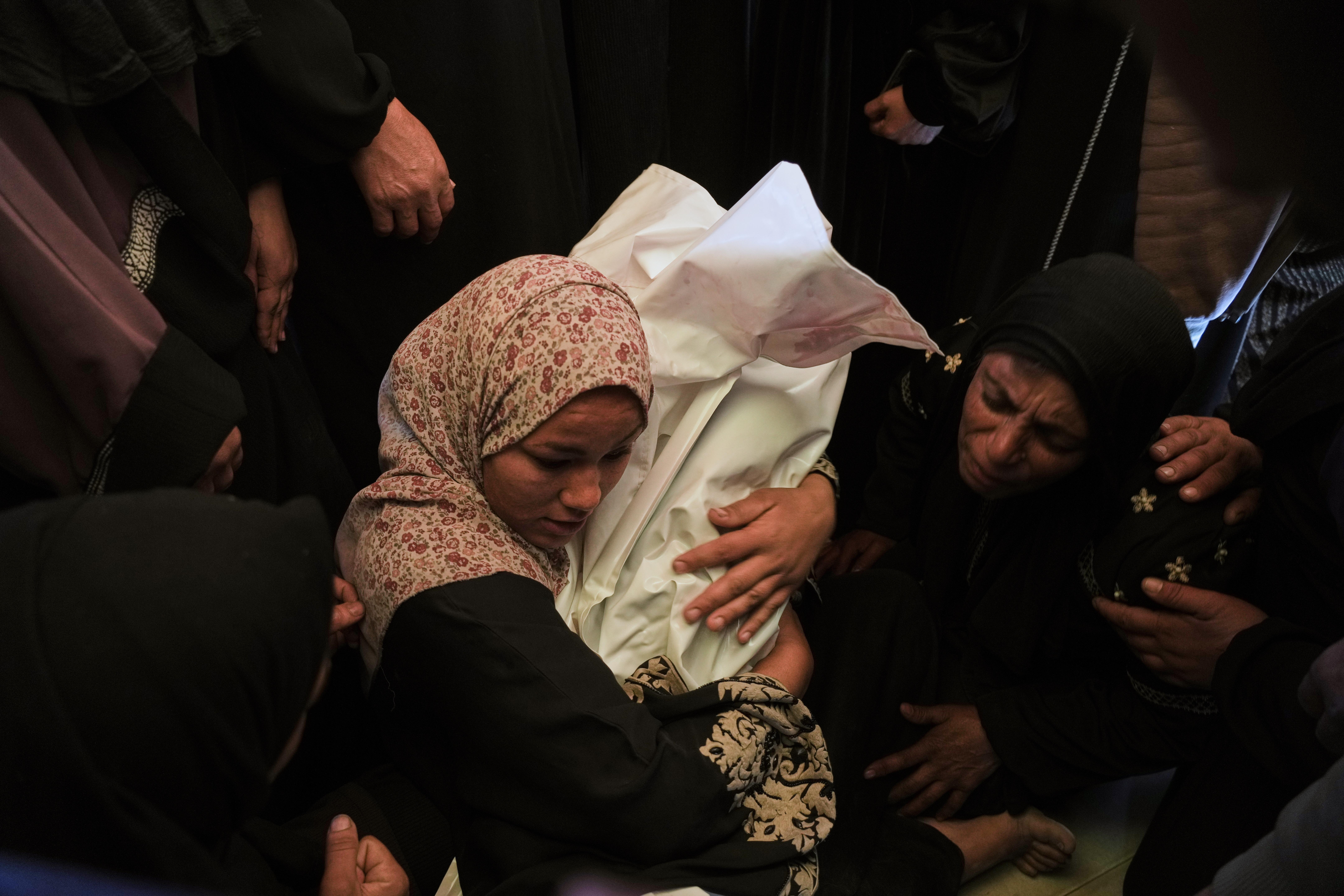 Khadija Abu Rabi cradles the body of her son, Iyad,...