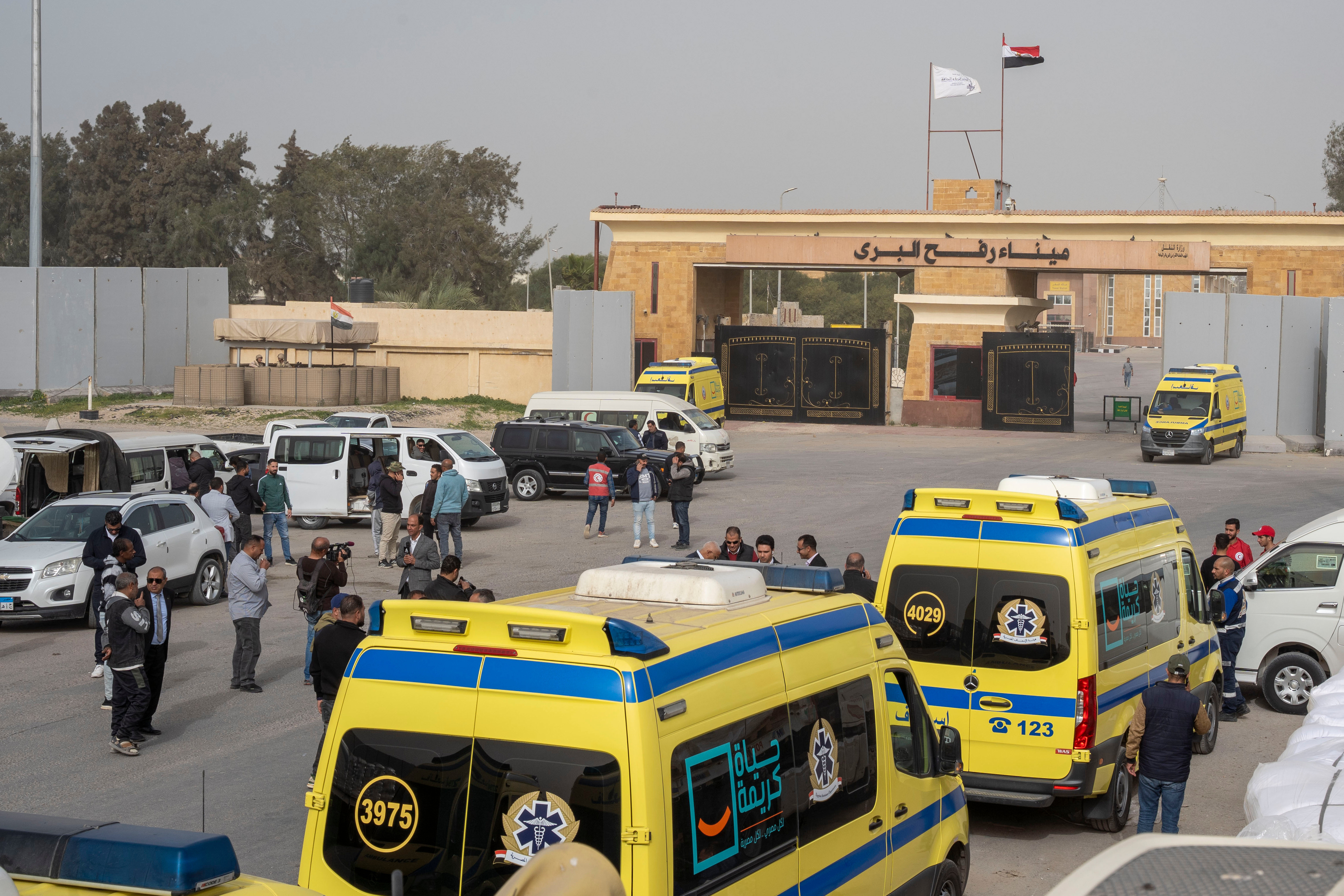 Ambulances line up to enter the Egyptian gate of the...