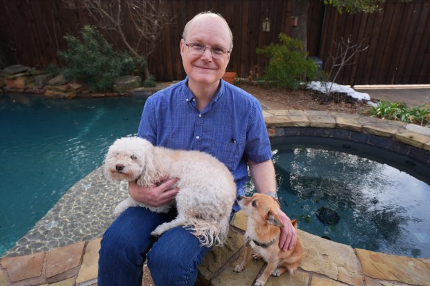 Dr. Daniel Moore poses for The Associated Press with his dogs Nani, left, and Gracie Feb. 2, 2026, in Coppell, Texas. (AP Photo/Julio Cortez)
