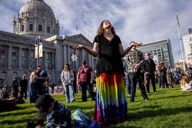 Attendees hold a moment of silence during a public memorial for Grateful Dead co-founder Bob Weir at Civic Center Plaza in San Francisco, on Saturday. (Stephen Lam/San Francisco Chronicle via AP)