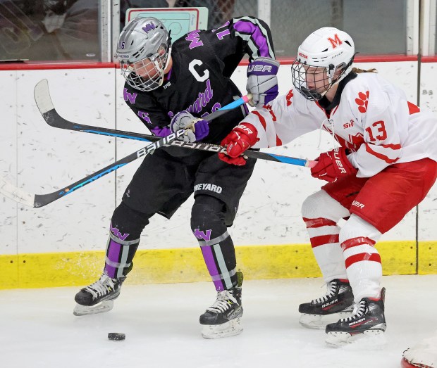 Martha's Vineyard Ashlyn O'Neill, left, and Milton's Marion Hart fight for the puck during a girls hockey game Monday. Milton skated to a 4-1 win. (Photo By Matt Stone/Boston Herald)