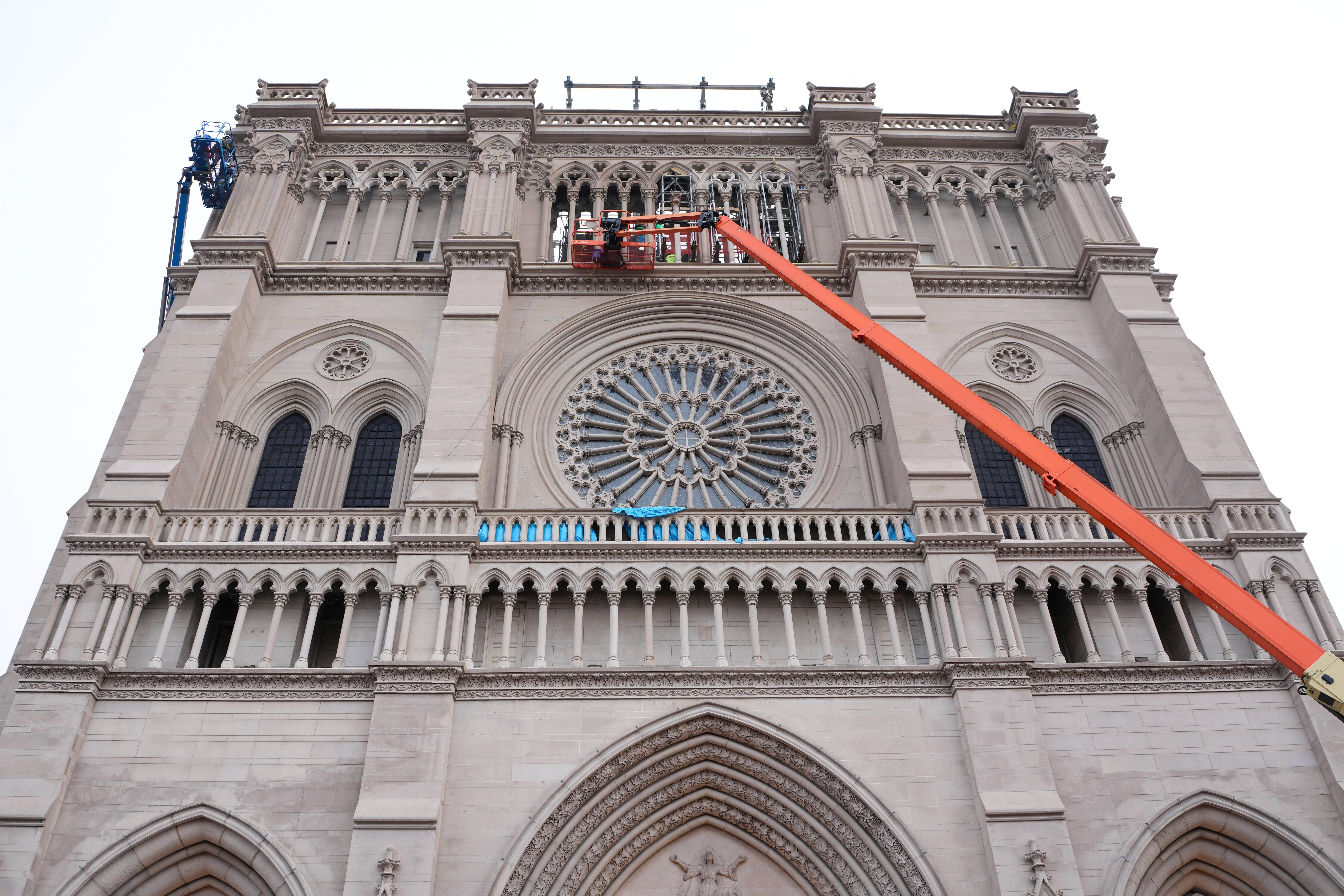 Workers install gargoyles on the Cathedral Basilica of the Assumption,...