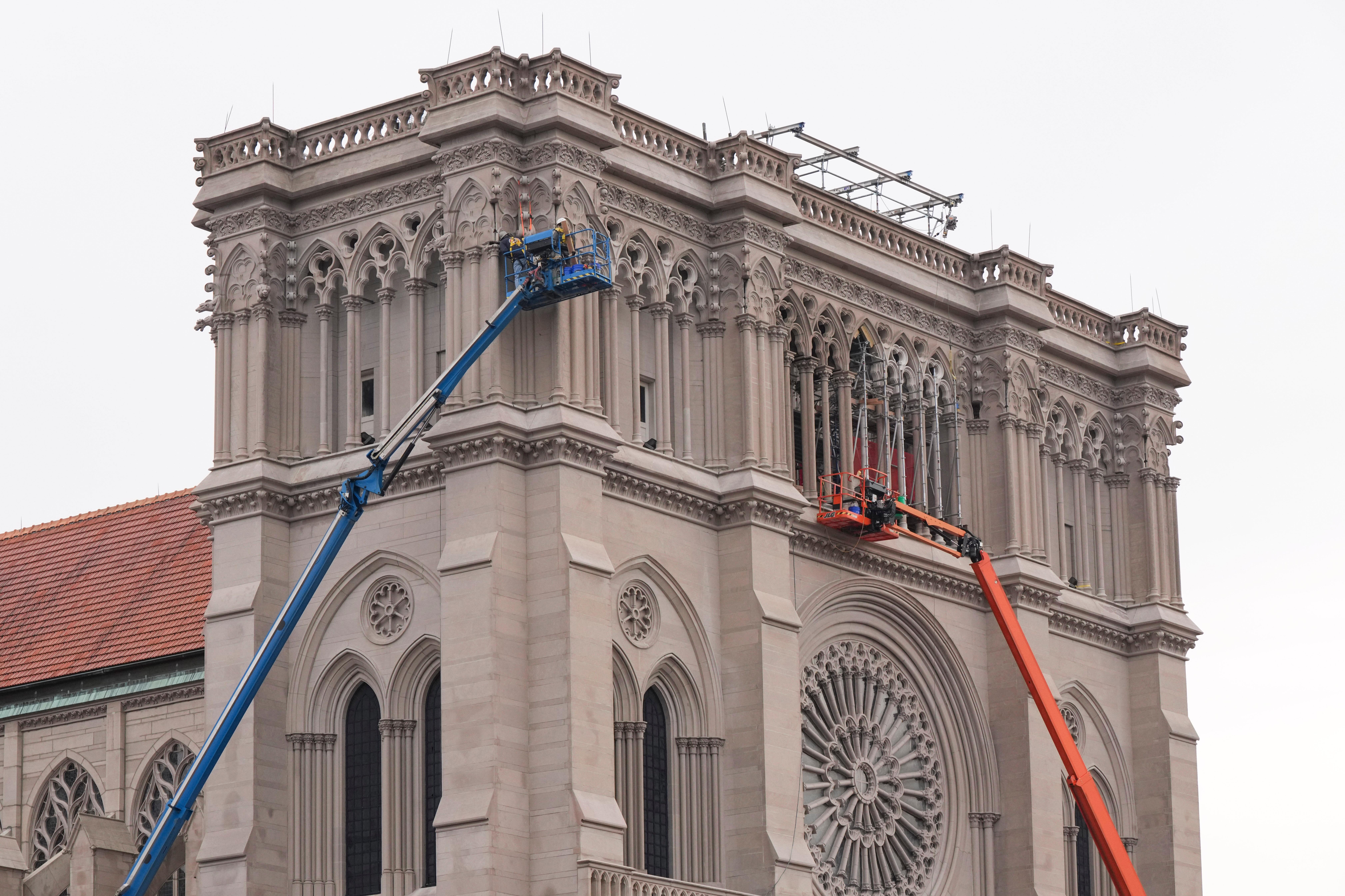 Workers install gargoyles on the Cathedral Basilica of the Assumption,...