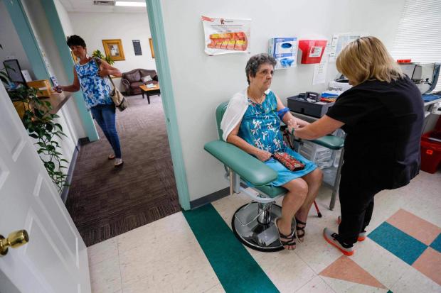 Faye Jackson gets her blood tested at a medical clinic in Calhoun, Ga., on Tuesday, Sept. 30, 2025, as her daughter Marie waits outside for her turn. Their blood tests revealed they have PFAS levels above the safety threshold outlined by national health experts. (Miguel Martinez/Atlanta Journal-Constitution via AP)