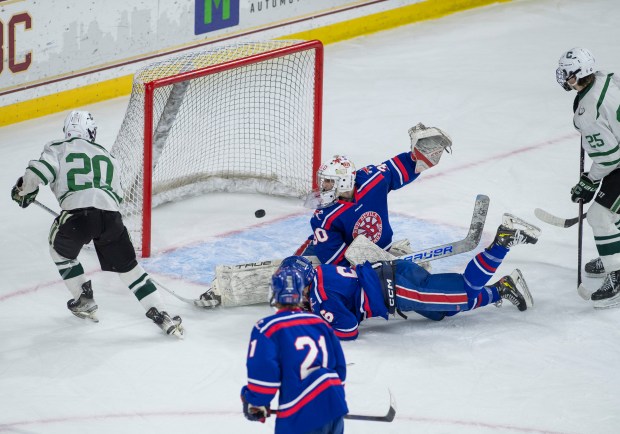 Canton's Joey Ryan (20) scores despite efforts from Burlington's goalie Colin MacLeod (30) and a dive by Michael Bannister (6) during the Div. 2 boys hockey semifinal at Boston College. (Amanda Sabga/Boston Herald)