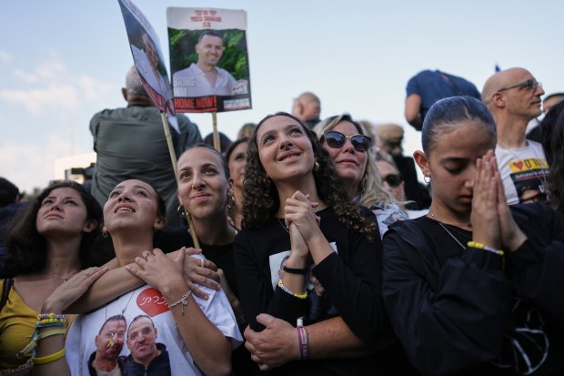 People react as they watch a live broadcast of Israeli hostages released from Gaza at a plaza known as hostages square in Tel Aviv, Israel on Monday. (AP Photo/Oded Balilty)