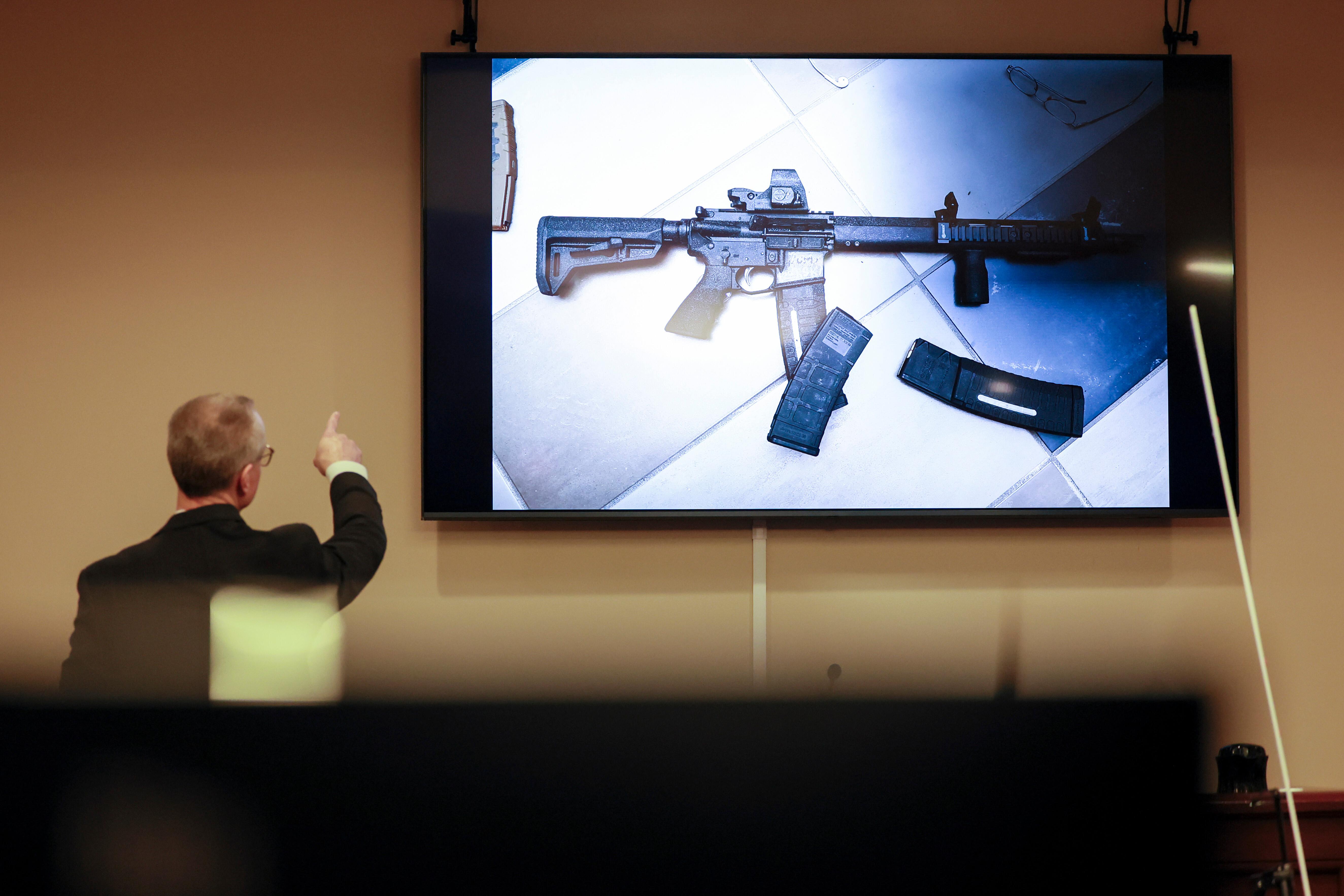 District Attorney Brad Smith, left, points to a weapon that...