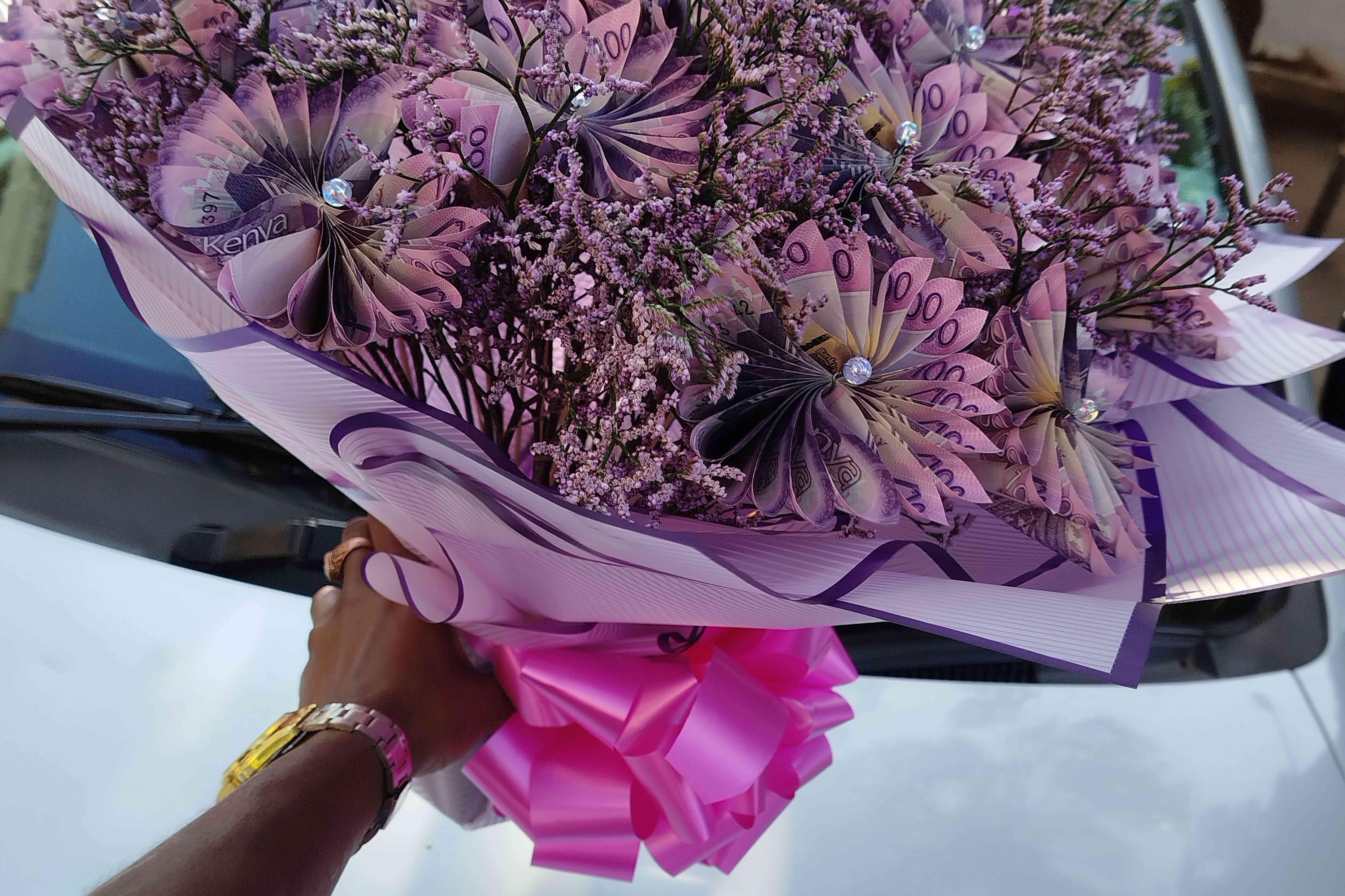 A vendor holds a flower bouquet that incorporates real money...