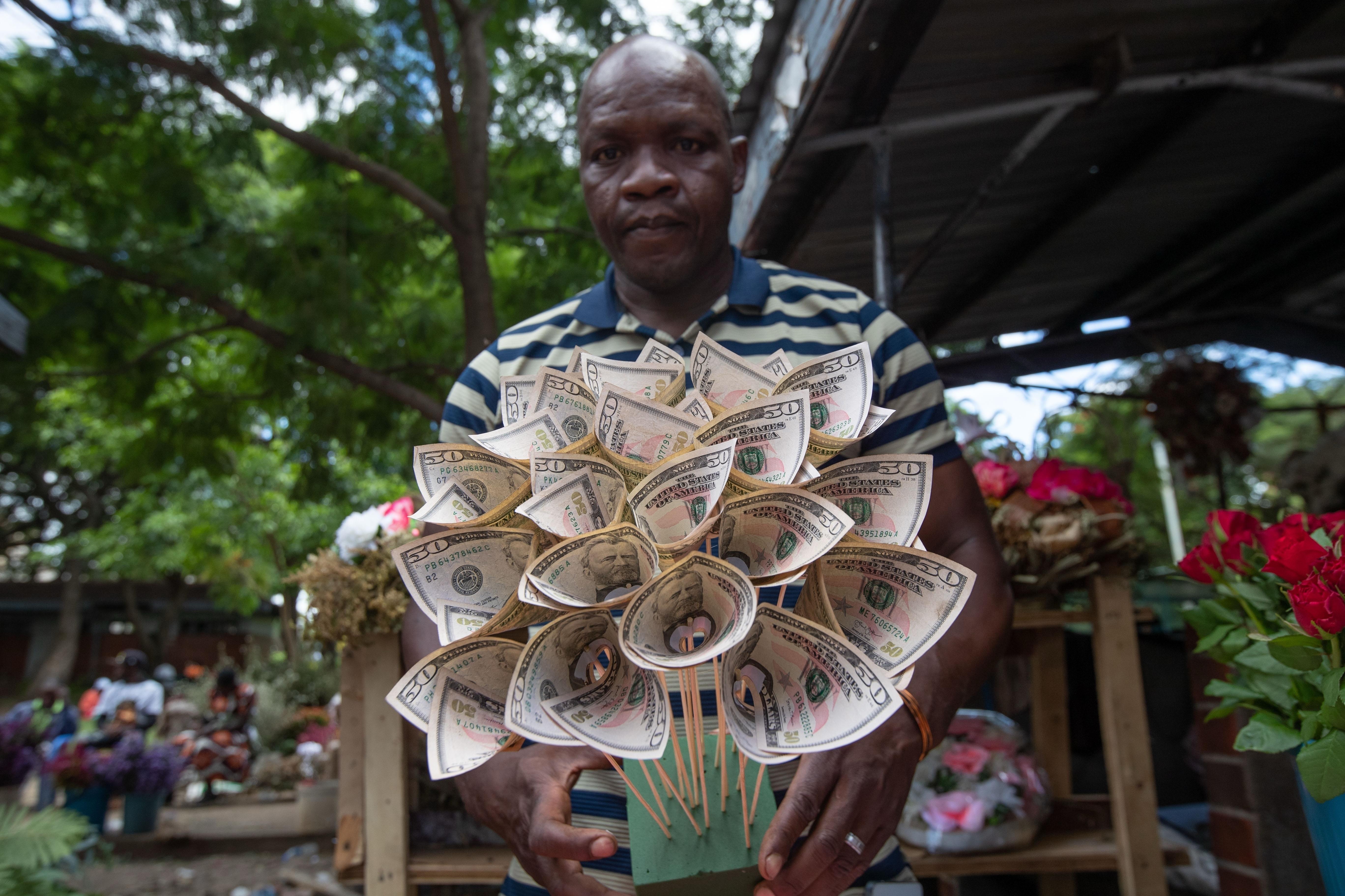 Florist Tongai Mufandaedza holds a money bouquet designed for Valentine’s...