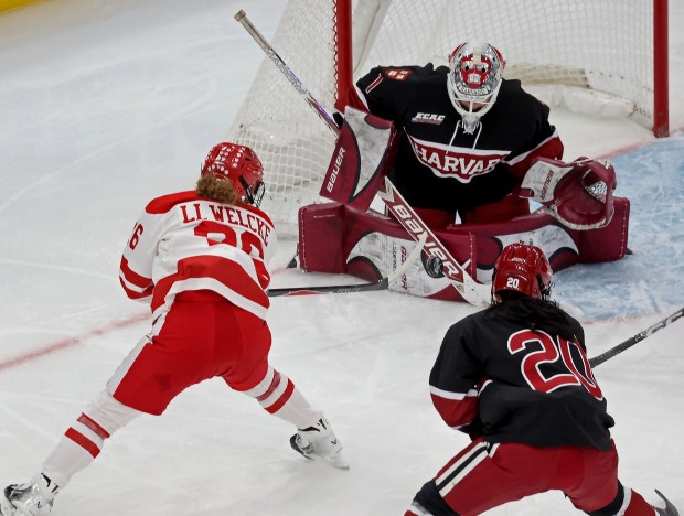 Boston University Terriers forward Lilli Welcke (26) fires the puck at Harvard Crimson left wing Ainsley Tuffy (1) as Harvard takes on BU in the Women's Beanpot championship. (Staff photo by Stuart Cahill/Media News Group)