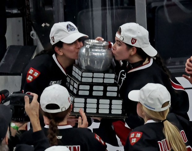 Harvard Crimson right wing Brooke Manning (19) and Harvard Crimson left wing Ainsley Tuffy (1) kiss the Beanpot as Harvard takes on BU in the women's Beanpot Championship. (Staff photo by Stuart Cahill/Media News Group)