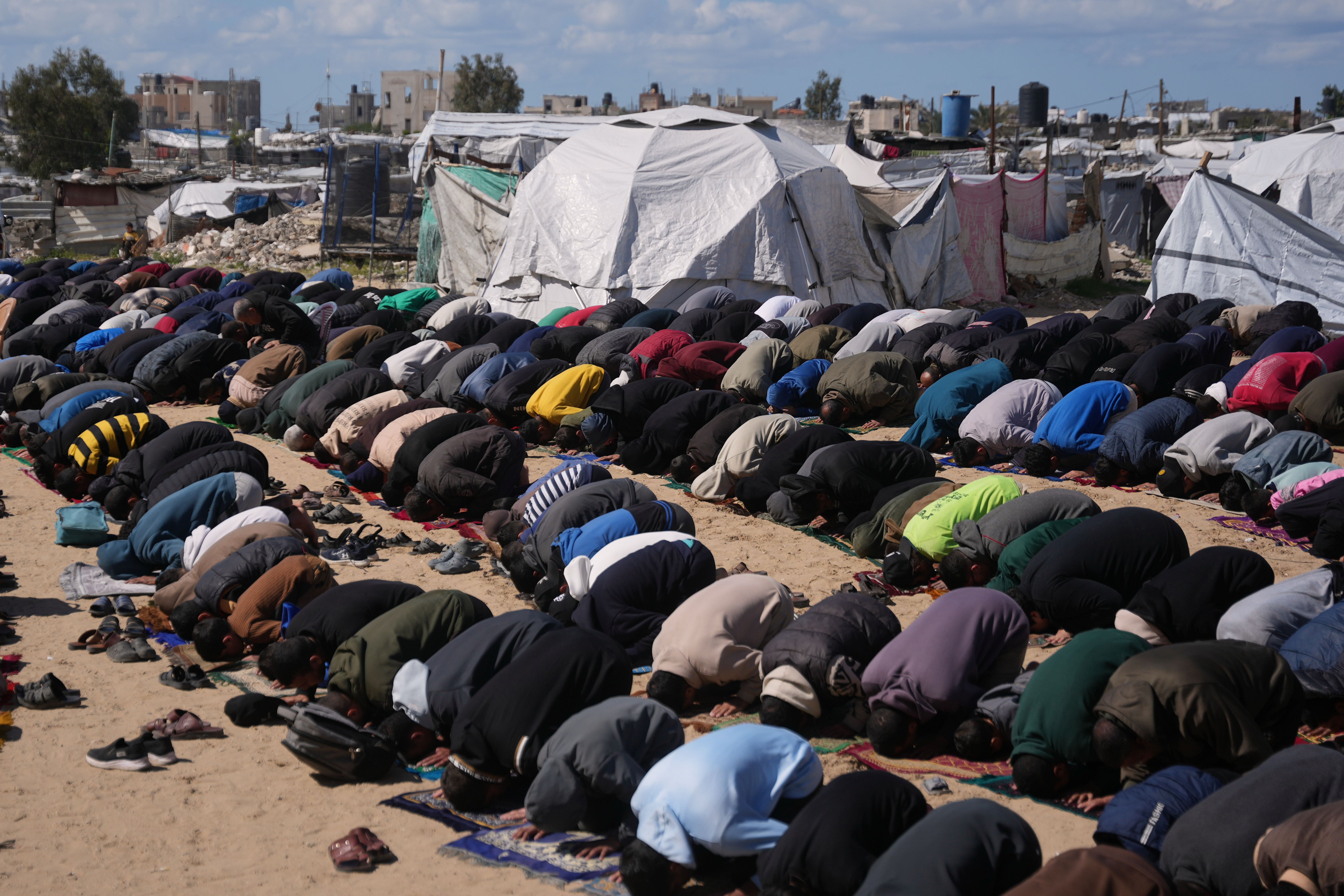 Muslim worshippers perform Friday prayers during the holy month of Ramadan outside the destroyed Al-Albani Mosque.