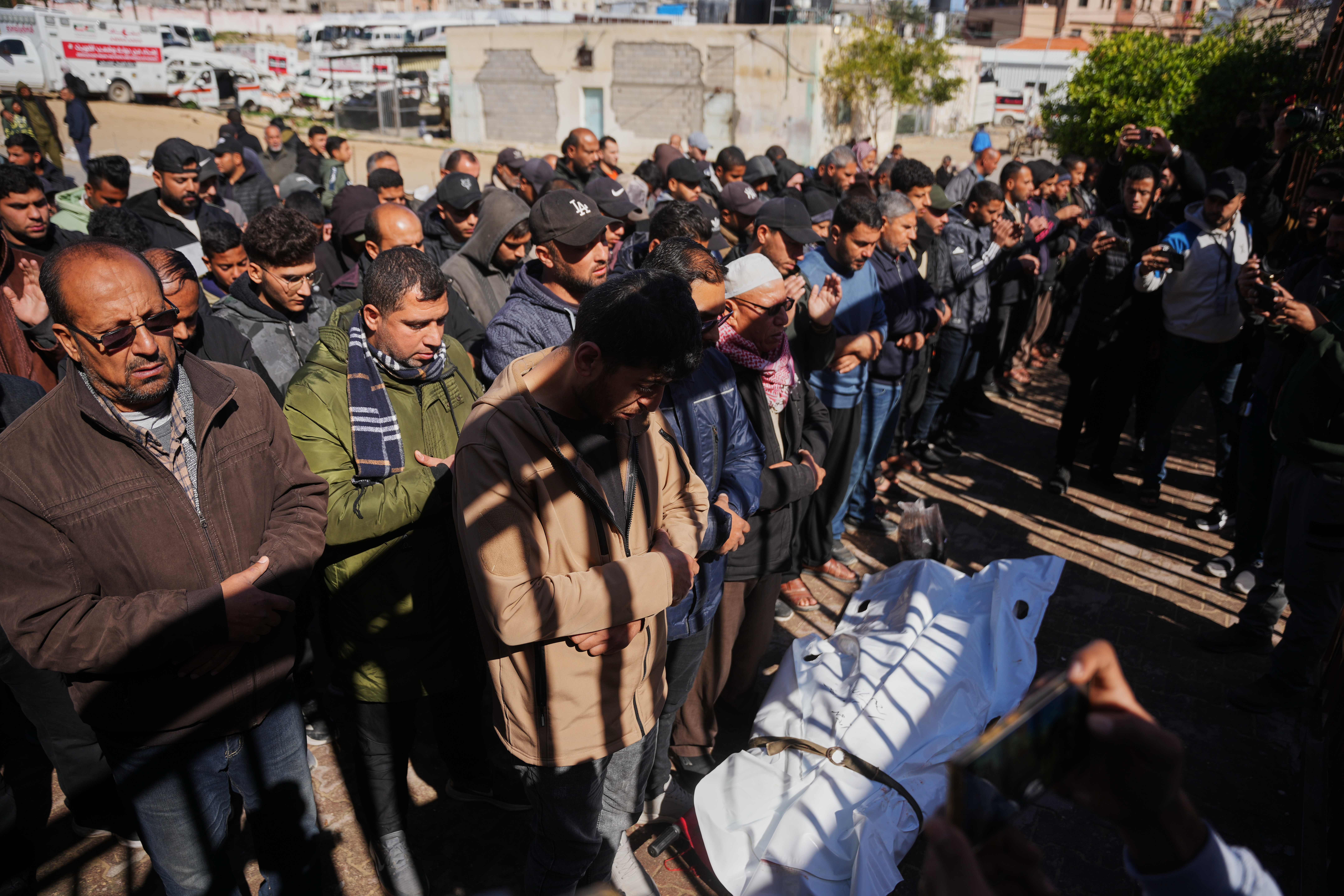 Mourners pray over the body of a Palestinian policeman who was killed in an Israeli military strike