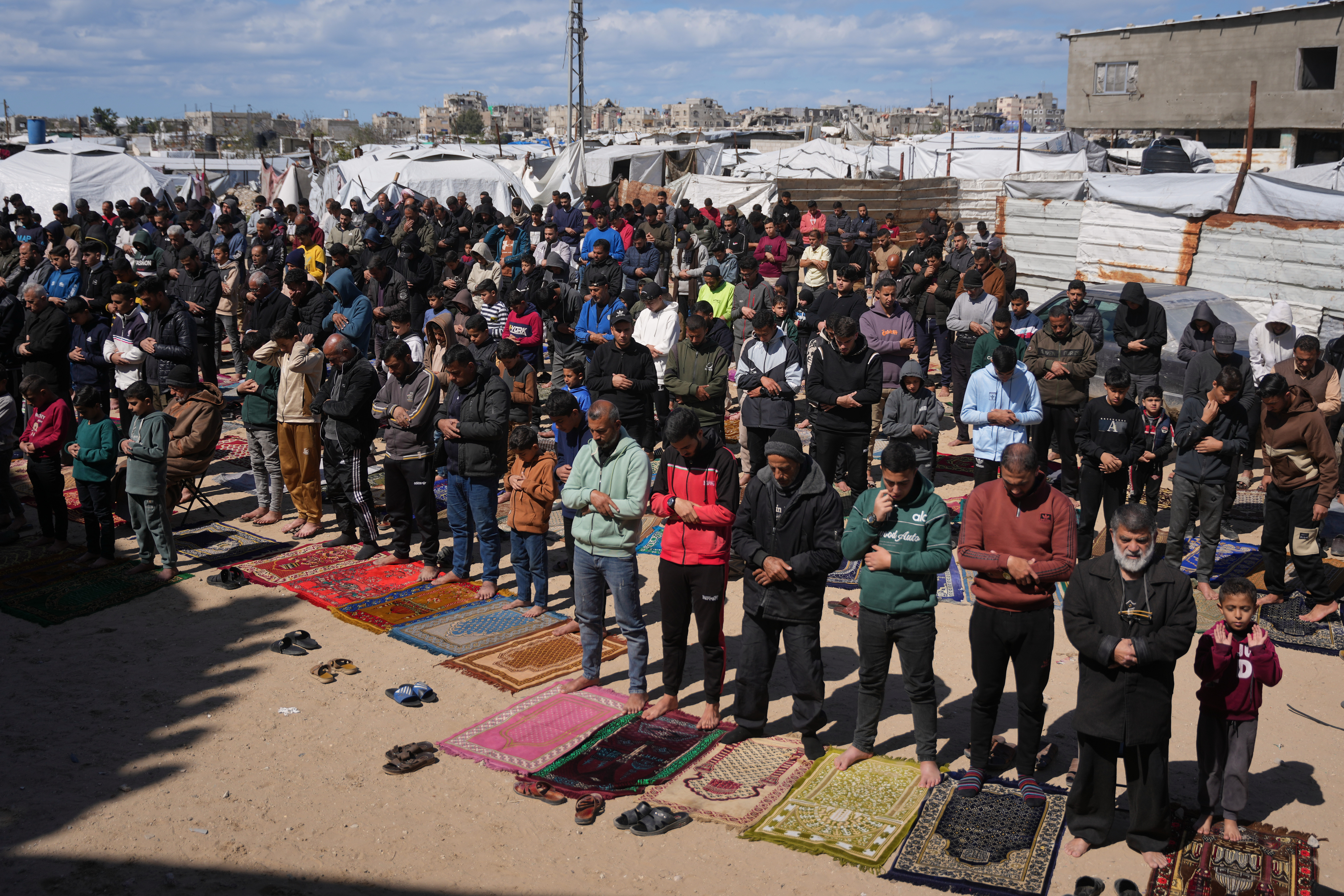Muslim worshippers perform Friday prayers during the holy month of Ramadan outside the destroyed Al-Albani Mosque.