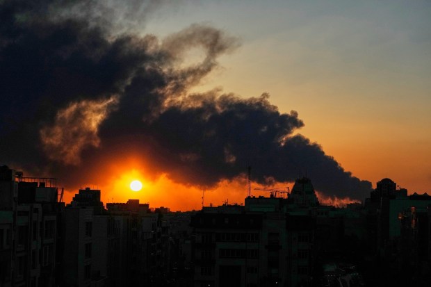 The sun sets behind a plume of smoke rising from a U.S.-Israeli military strike in Tehran, Iran, Tuesday, March 3, 2026. (AP Photo/Vahid Salemi)