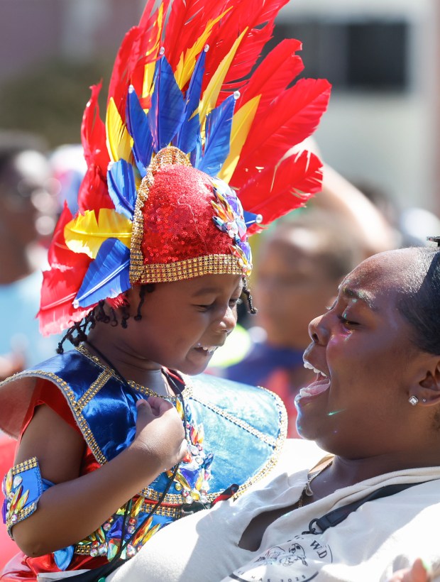Nasir Nelson, 3, left, dances in the arms of his mother Maia Porter, right, during the Boston Society of Caribbean Culture and Heritage's Kiddie Carnival. (Paul Connors/Boston Herald)