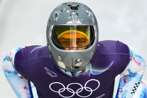 Ukraine's Vladyslav Heraskevych arrives at the finish during a men's skeleton training session at the 2026 Winter Olympics, in Cortina d'Ampezzo, Italy, Wednesday, Feb. 11, 2026. (AP Photo/Alessandra Tarantino)