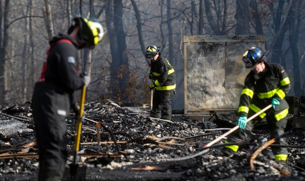 Fire crews rake through rubble at the construction site next to the Olympia Place student housing apartments in Amherst on Saturday. (Daniel Jacobi II/The Daily Hampshire Gazette via AP)